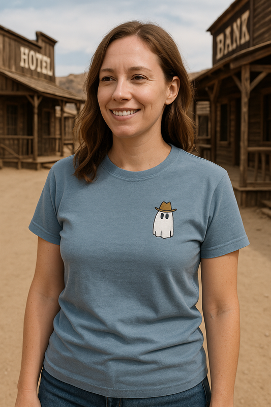 Woman wearing a blue t-shirt with a ghost in a hat graphic in front of a western-themed backdrop.